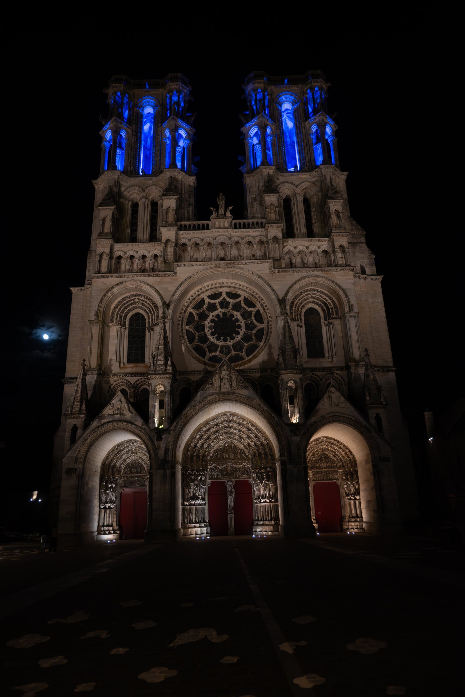 Cathédrale de Laon illuminée en bleu la nuit avec la pleine lune